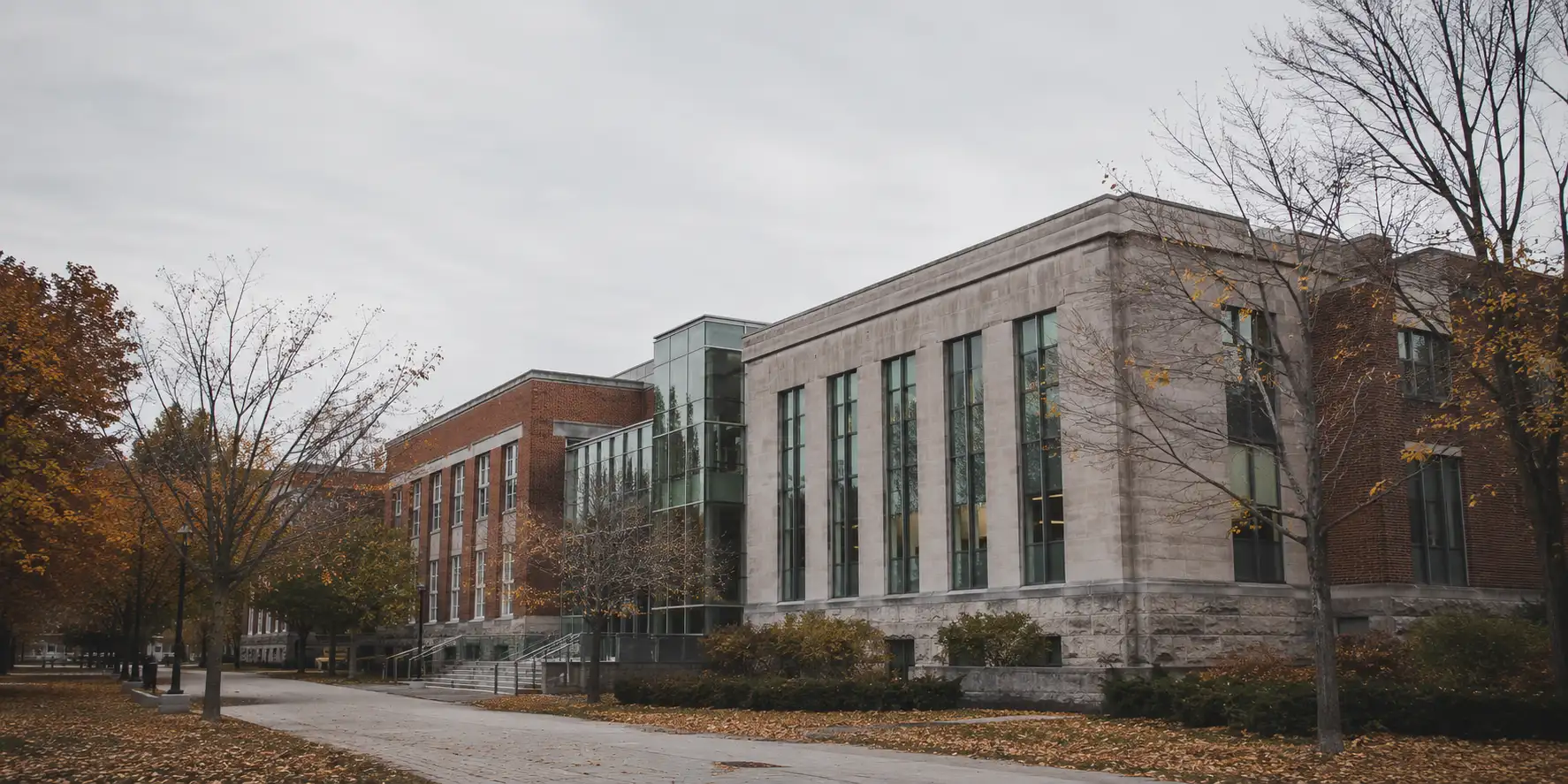 A Canadian university campus in late autumn, brick, stone and glass under overcast daylight